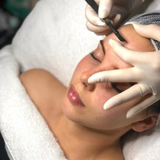 Aplicação de dermaplaning no rosto da cliente